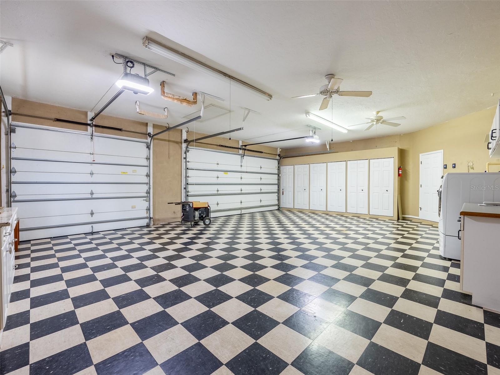 3 ceiling fans keep the garage workbench area cool, while the row of storage shelves with 6 doors provides TONS of organized storage.