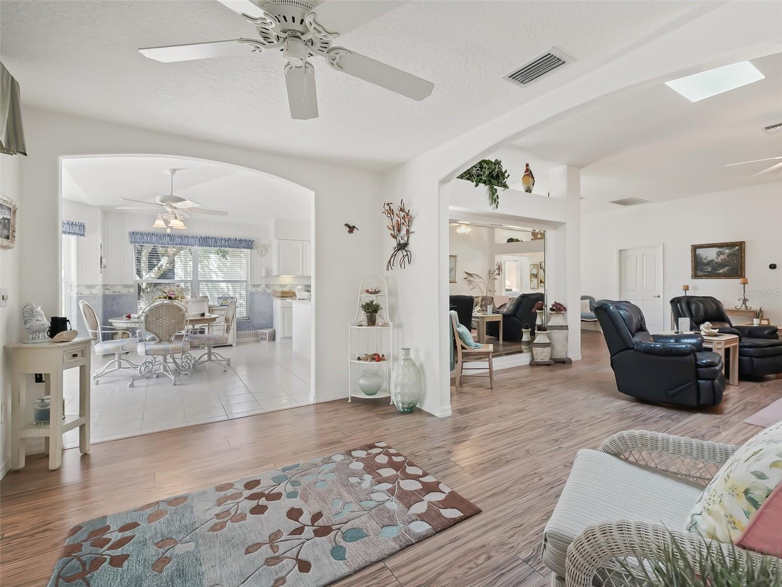 Living room view and looking into kitchen eating area - notice the large arches