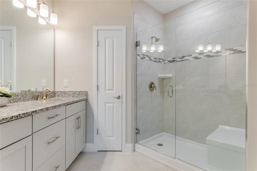 Main Bathroom with Frameless glass shower, built-in seat, and listello tile