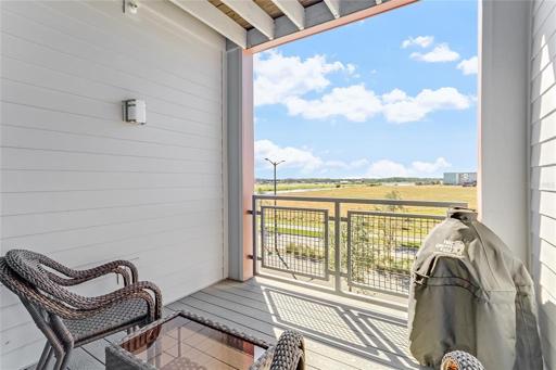 Lovely covered patio with view of agricultural area and water 