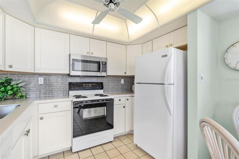 The kitchen has newer cabinets, Corian counters and complimentary tile backsplash.