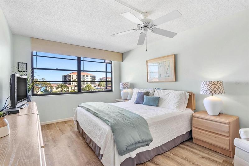 Primary bedroom has partial water views from the double windows and also has beautiful contemporary laminate flooring