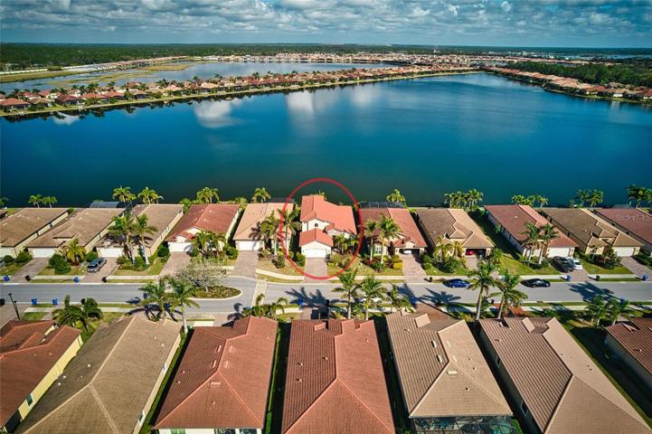 Aerial of the front of the home and expansive lake in the back of the home.