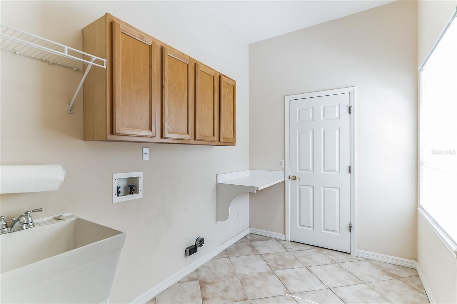 Spacious Laundry Room with storage closet and sink