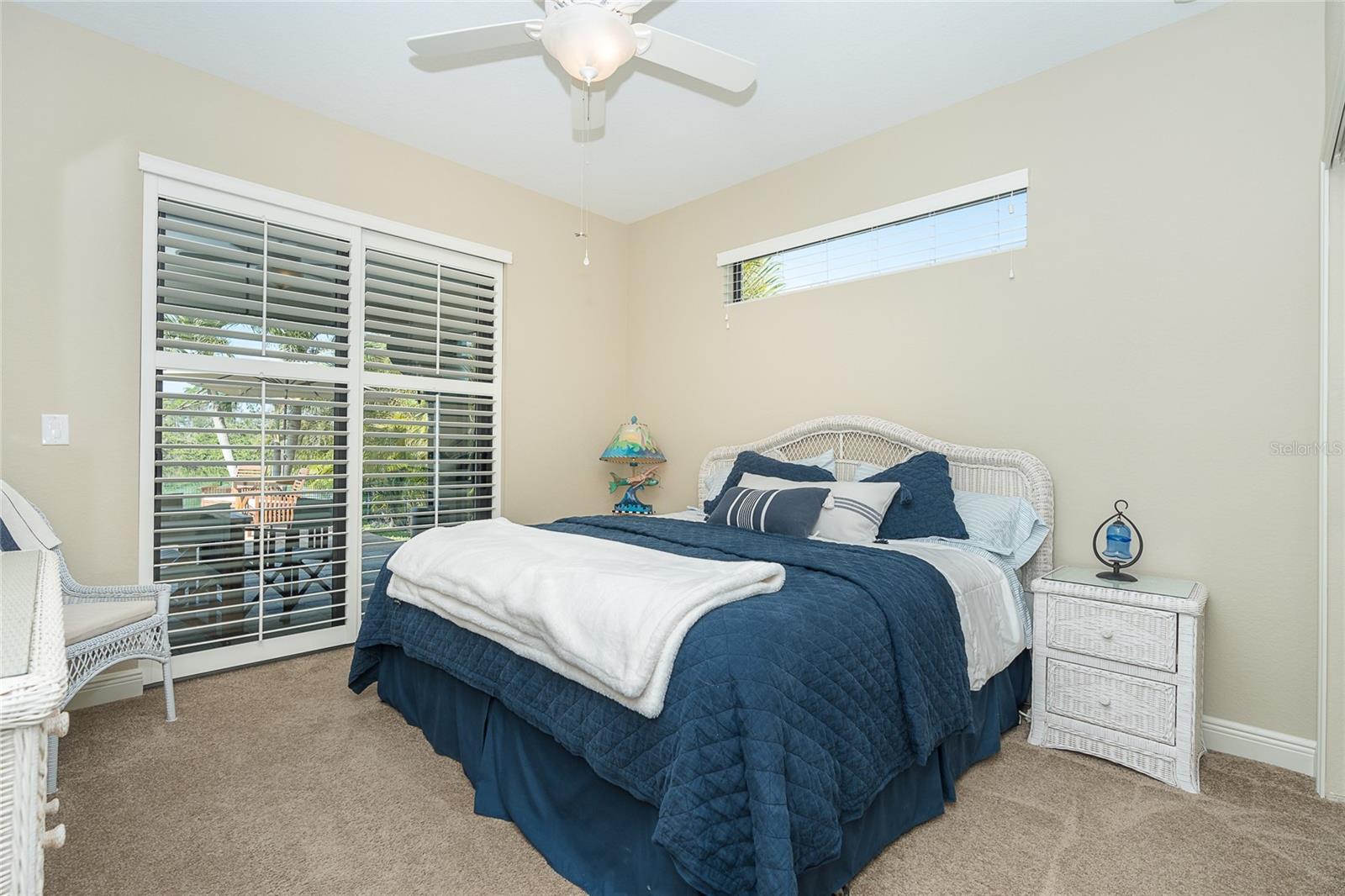 Guest Bedroom 2 with custom plantation shutter that lead out to the patio/lanai space