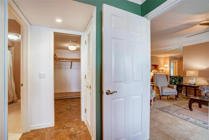 The master walk in closet has wooden shelving and hangers, plus a generous shoe rack.