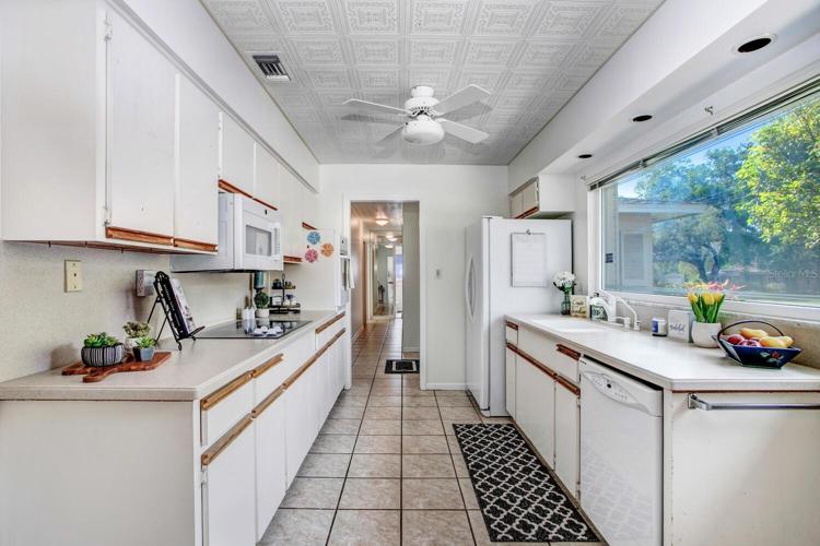 The kitchen sink looks out the large, front, double-paned window. There's lighting over the window too!