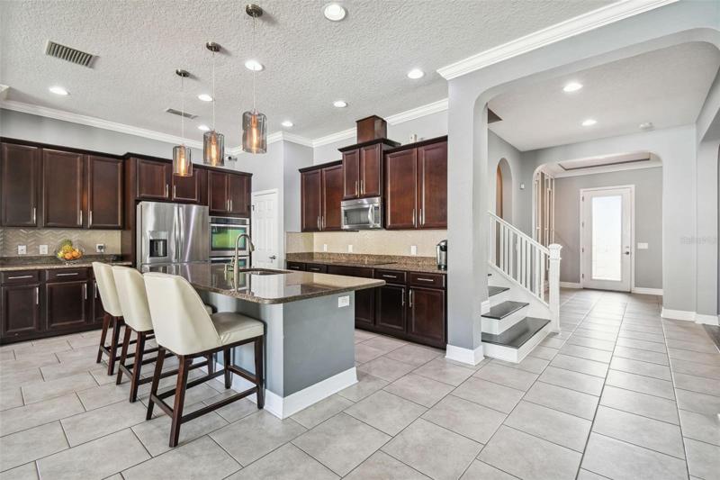 The kitchen and family room are at the rear of the home and there are large windows to let in natural light and look out to the yard. 