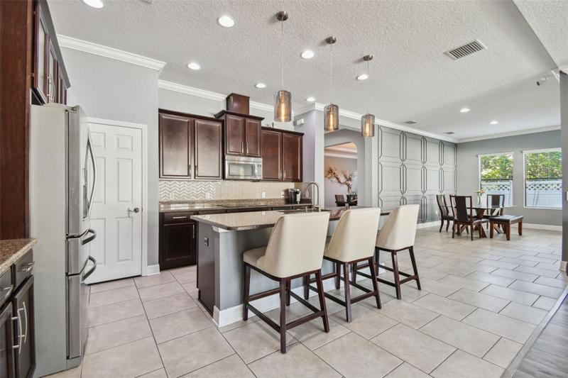The kitchen is the center of the home and features 42" wood cabinets with crown molding, granite counters, beautiful tile backsplash and decorative pendant lights over the island. Stainless steel appliances and a large walk in pantry complete the kitchen.