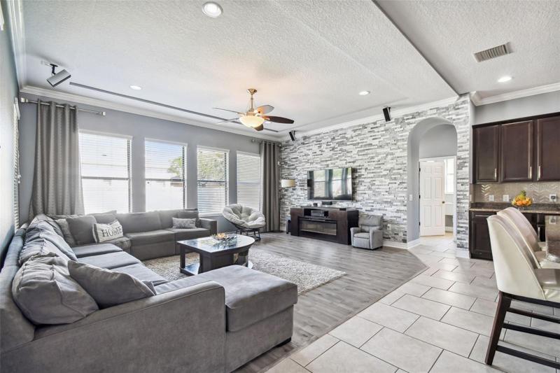 The family room features a decorative stone wall and a tray ceiling. 