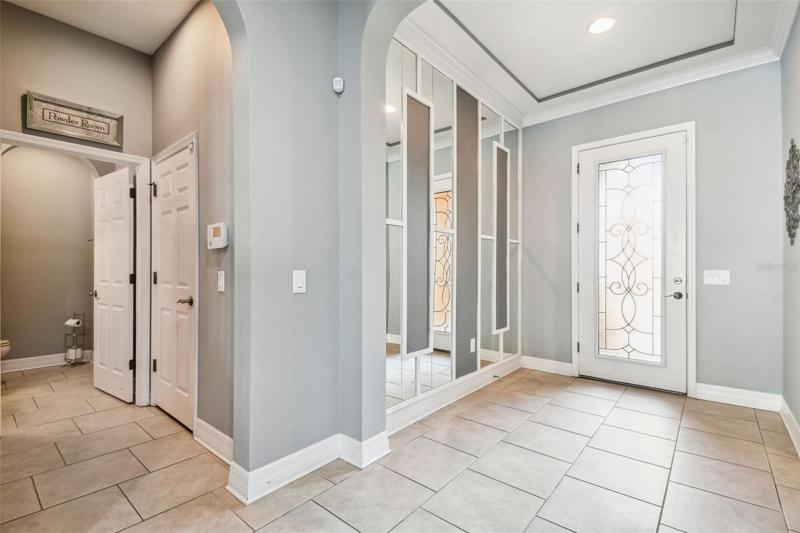 The foyer entry has crown molding and a decorative wall feature.
