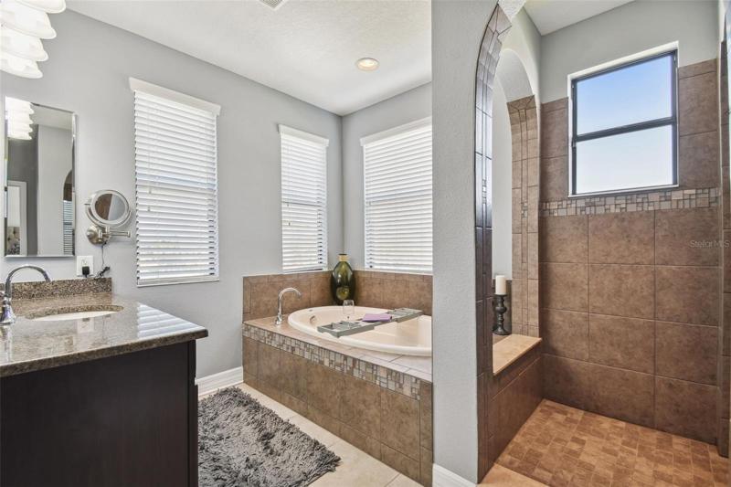 The master bath is luxurious with two separate vanities, a garden tub, oversized walk in shower and a large walk in closet.
