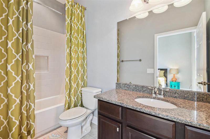 This is the ensuite bath for bedroom 5 on the first floor and features a granite top vanity and tub/shower.
