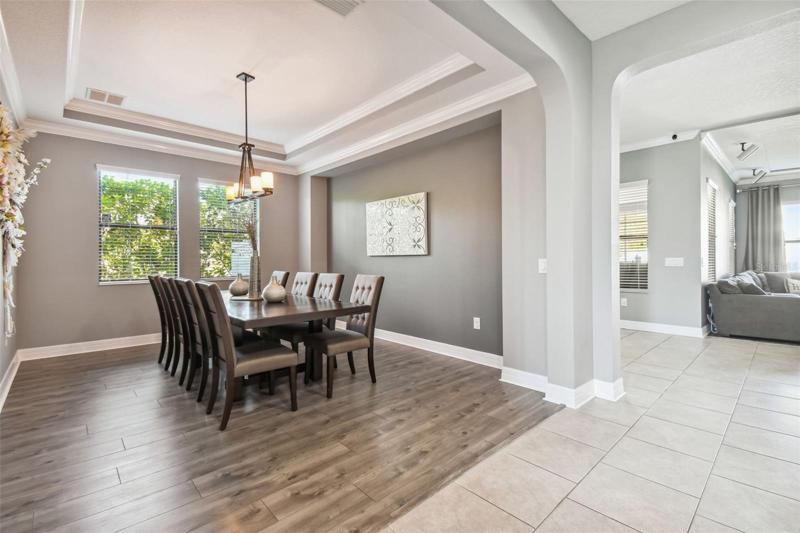 The master suite features a large bedroom with a decorative tray ceiling. The windows bring in lots of natural light. 