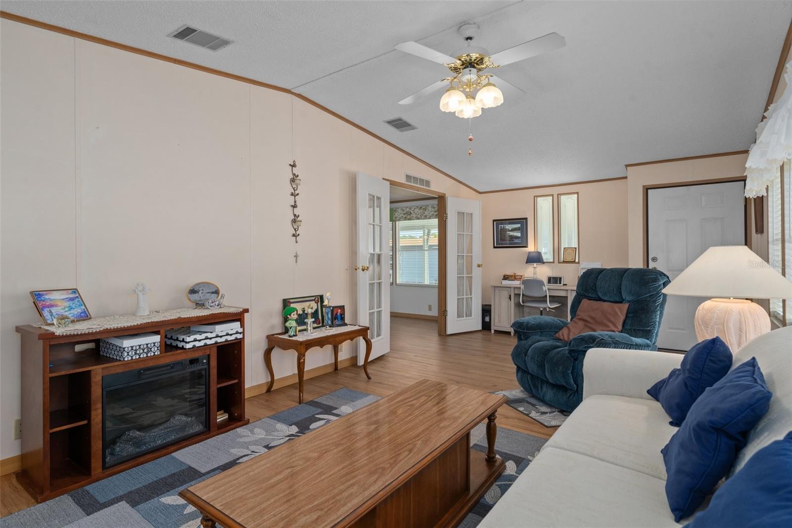 Living Room with Luxury vinyl floors and French Doors leading into Kitchen