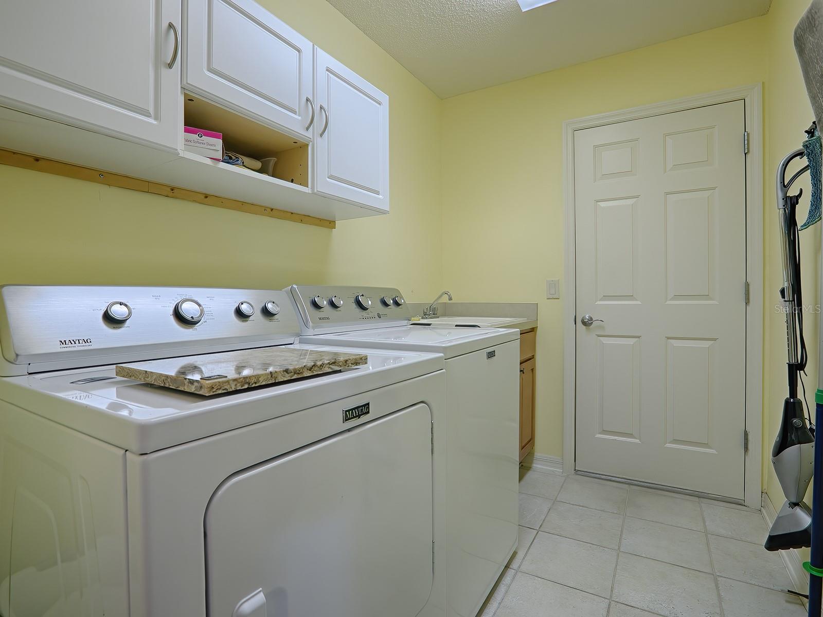 LAUNDRY ROOM HAS CABINETS AND A SINK