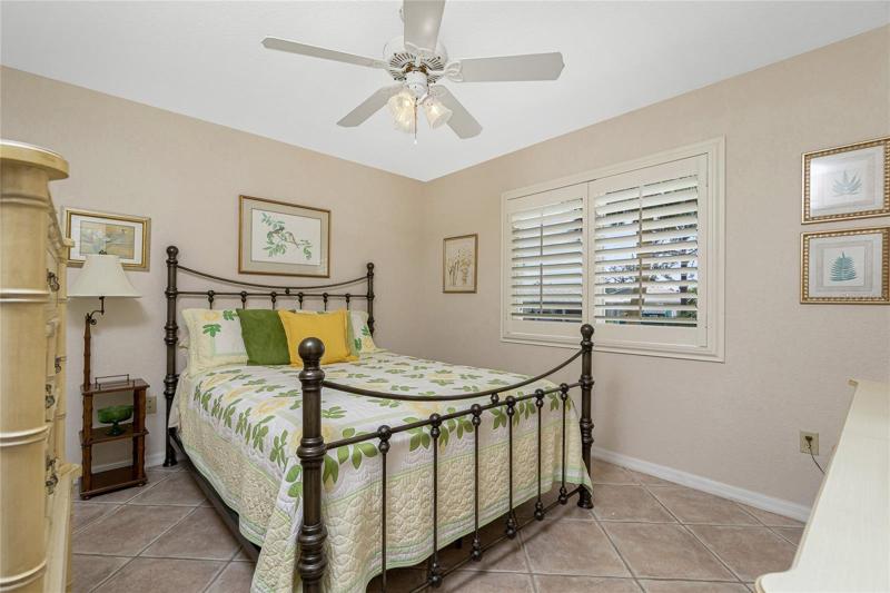 The guest bedroom features a tiled floor and nice neutral tones.