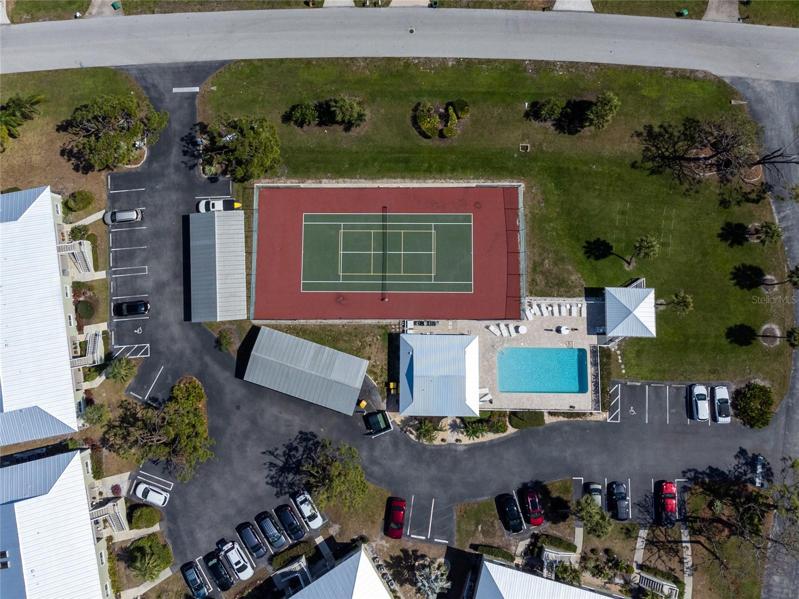 Birds eye view above Golden Tee show the pool area and tennis court.