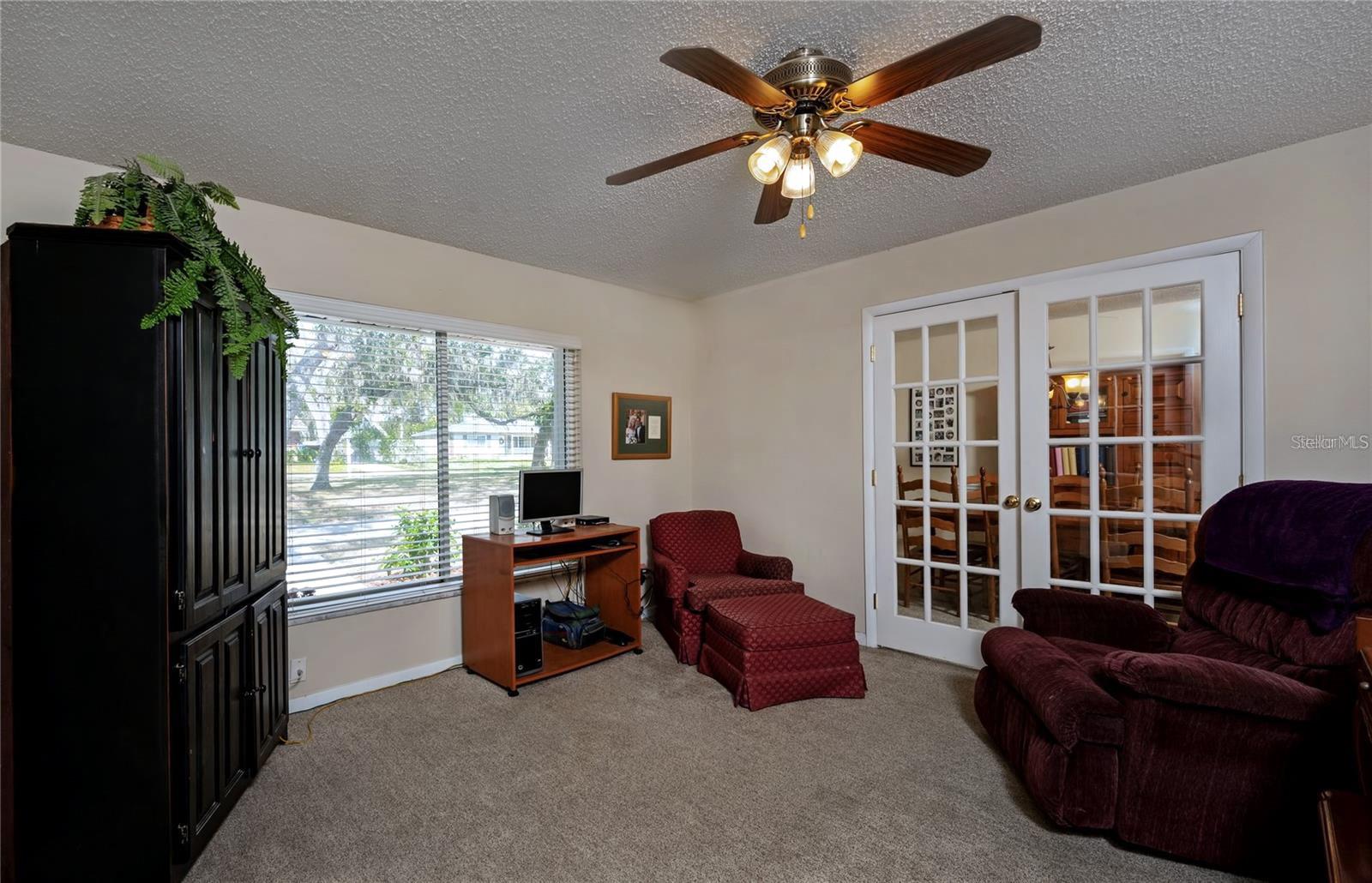 French doors are either side of this room that can be used as an office, den, or living room.