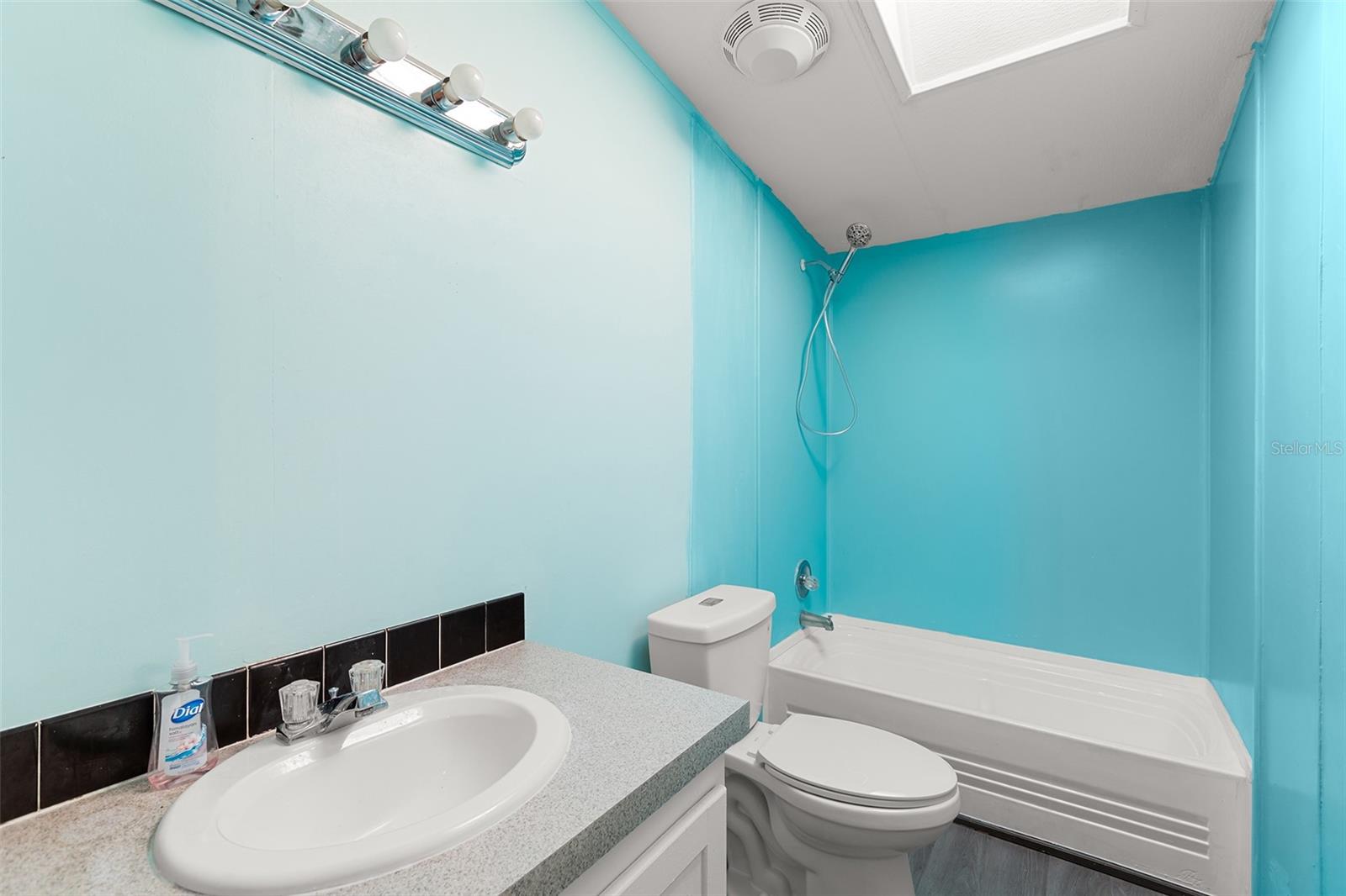Second bathroom with tub/shower and single sink vanity