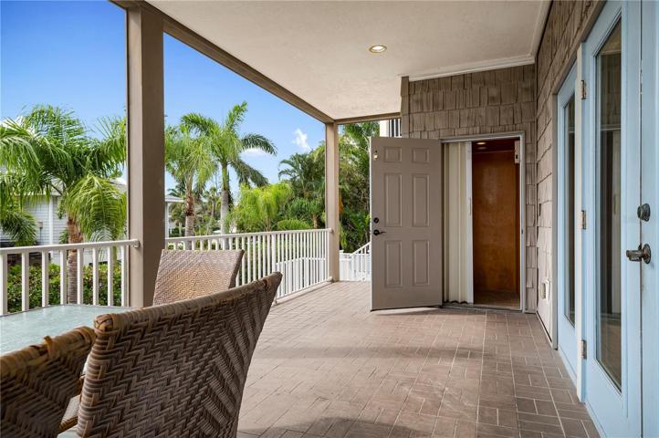 Living room patio with dining al fresco and the elevator to all three floors