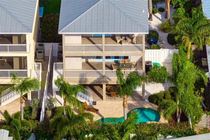 Aerial view of back of home with covered patio's on all three levels