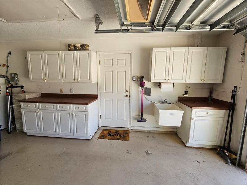 Garage with built-in cabinets and mudsink