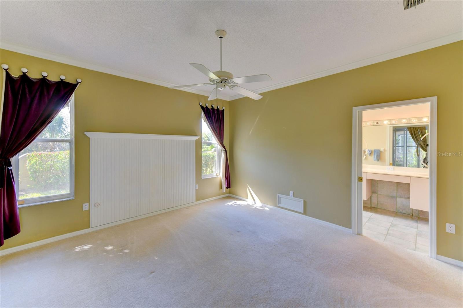 Light and bright main bedroom with a ceiling fan