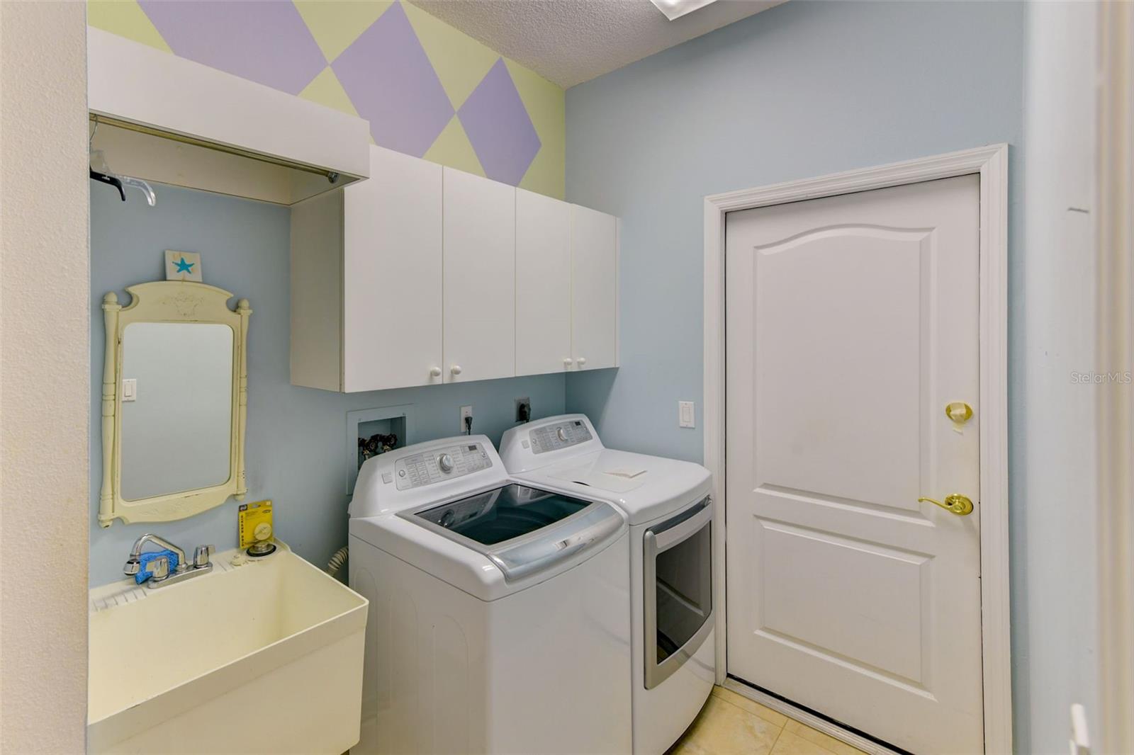 Laundry room with utility sink and cabinet