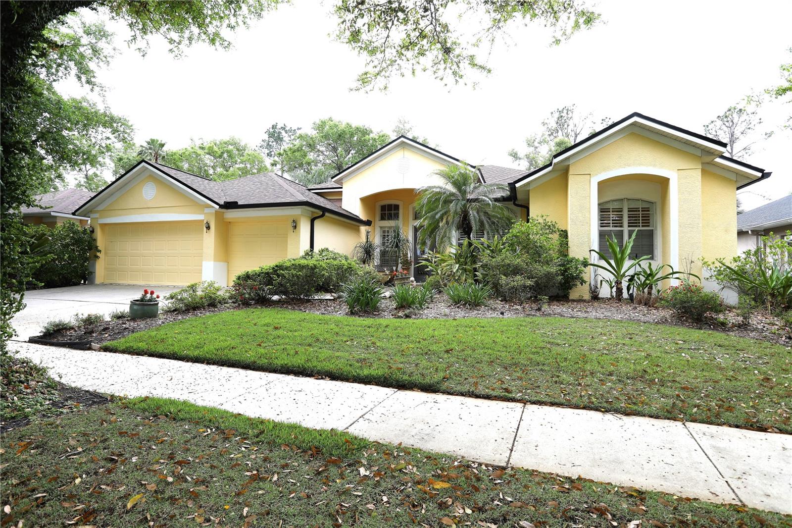 Exterior, lawn is zoysia grass and there are many different plants including gardenias, azaleas, ginger, lilies of the nile and roses.