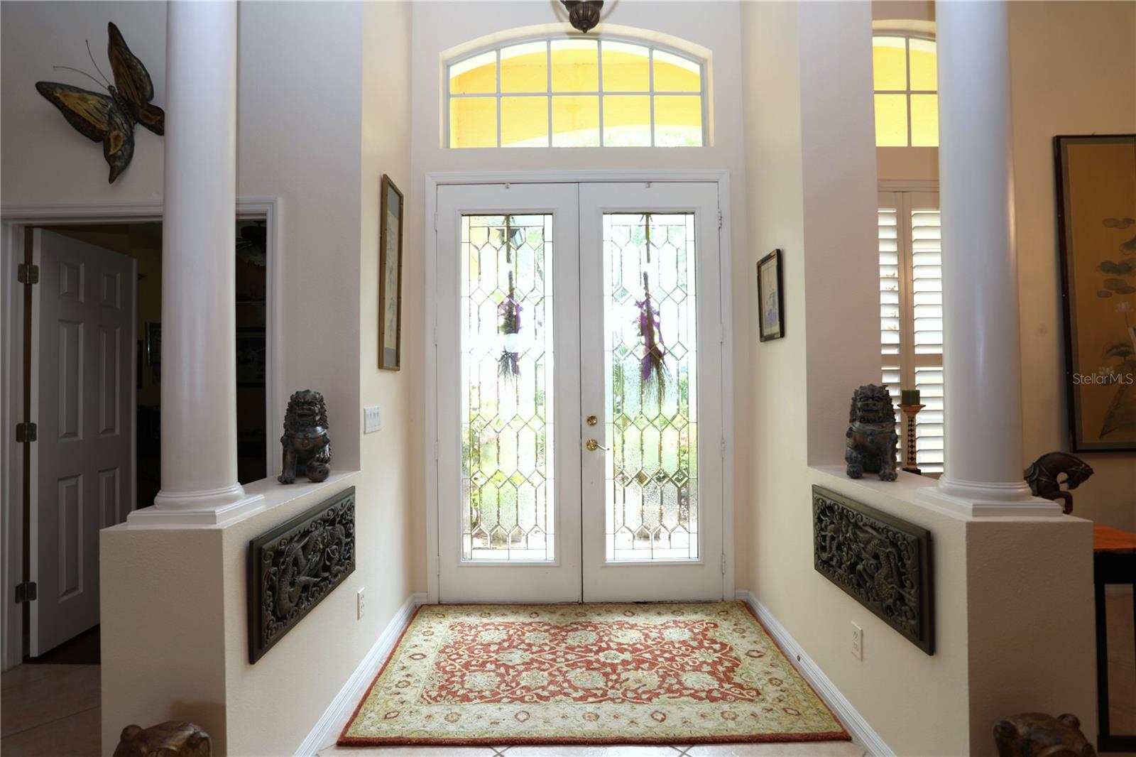 Front door from the living room.  Dining room on the right with plantation shutters and 5th bedroom on the left