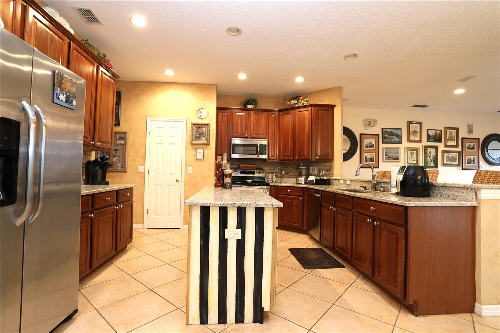 Kitchen features large island with Mackenzie Childs design