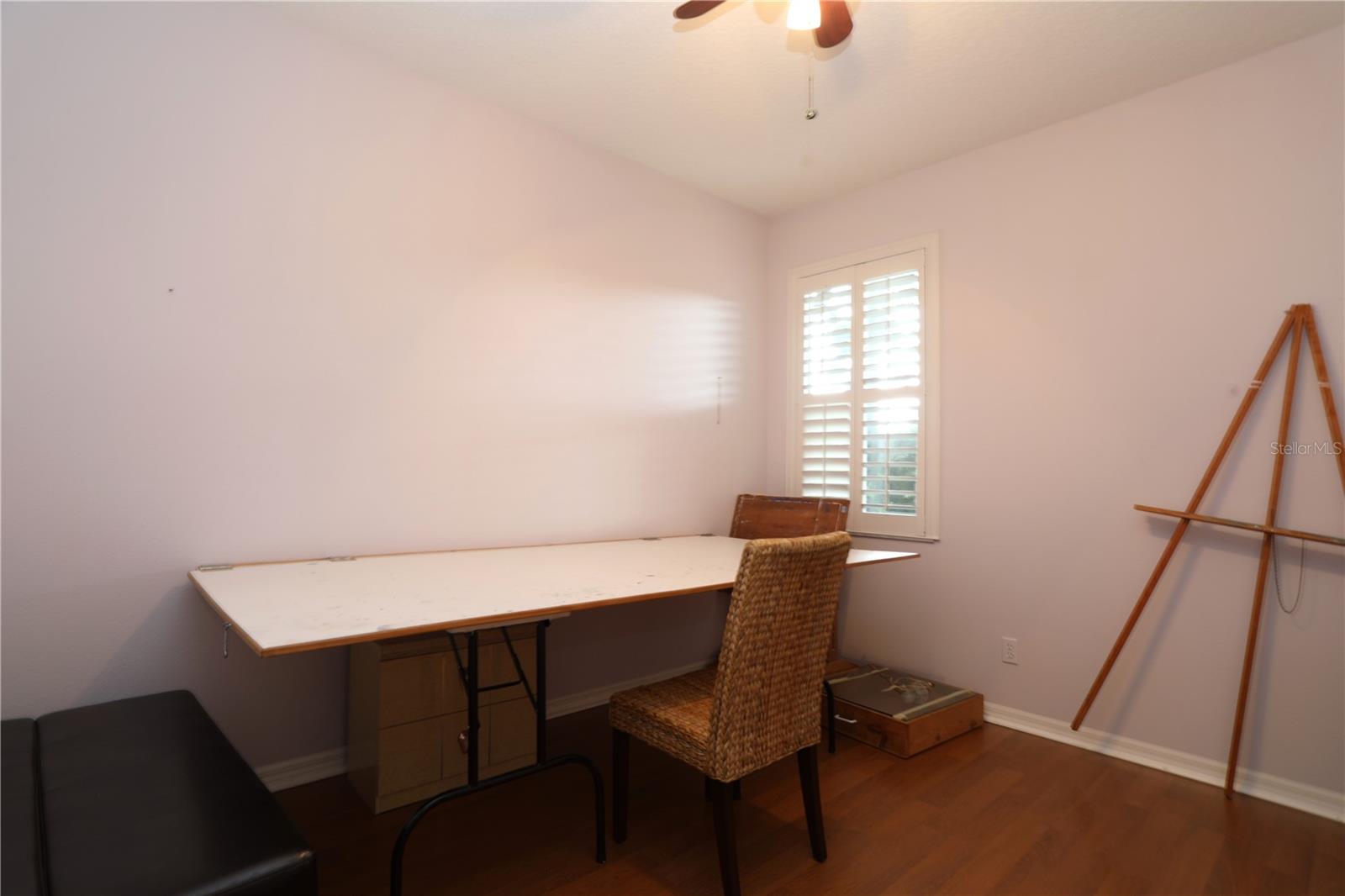 Bedroom 3, currently used as an arts and craft room.  table can be left or removed at buyers' option.  It folds up against the wall.  Laminate floors.