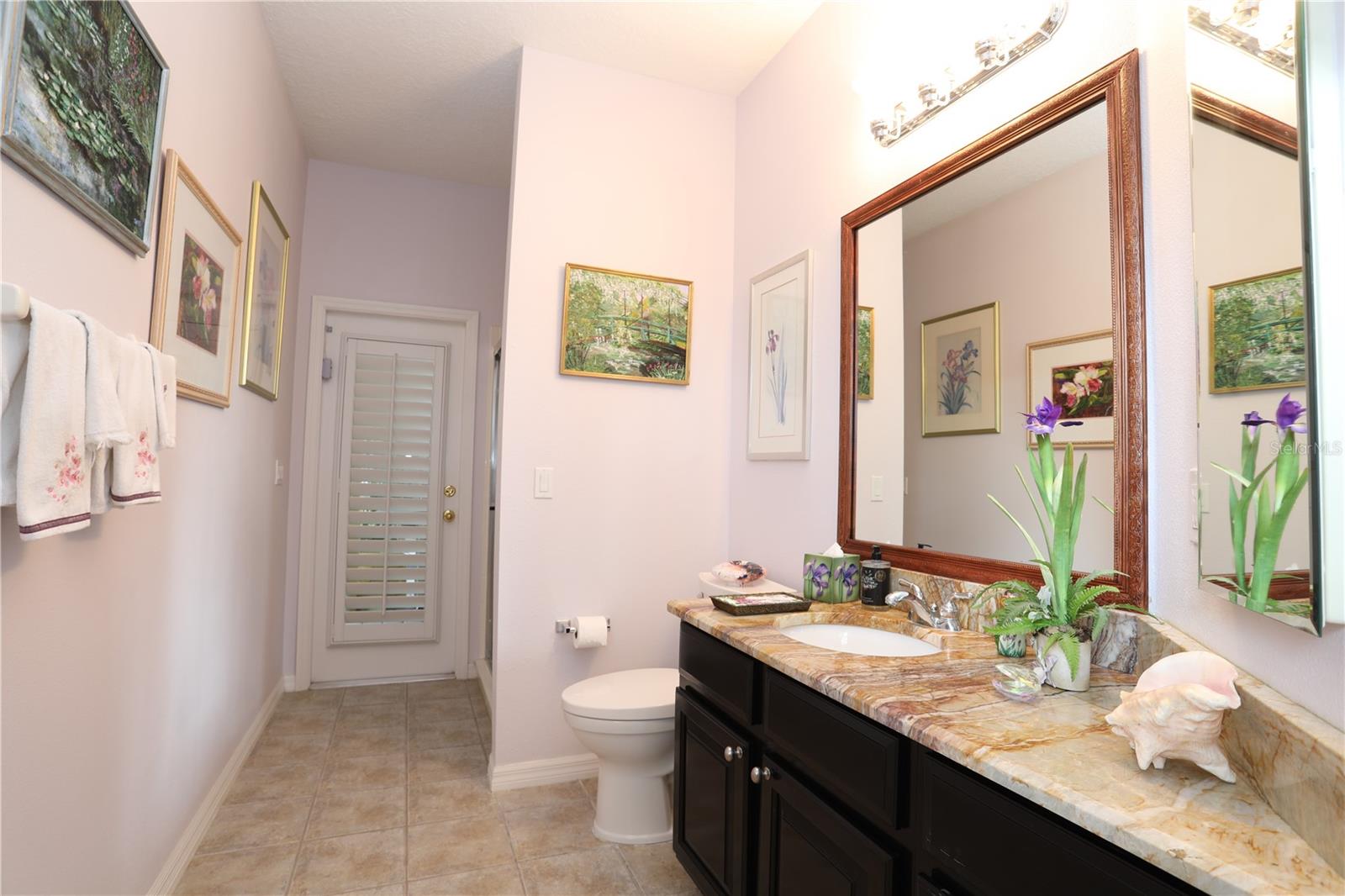Pool bath leads out to lanai. Vanity has granite counter top..