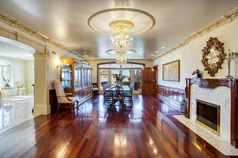 The stately Formal Dining Room offers exquisite custom molding and an inviting wood-burning fireplace.