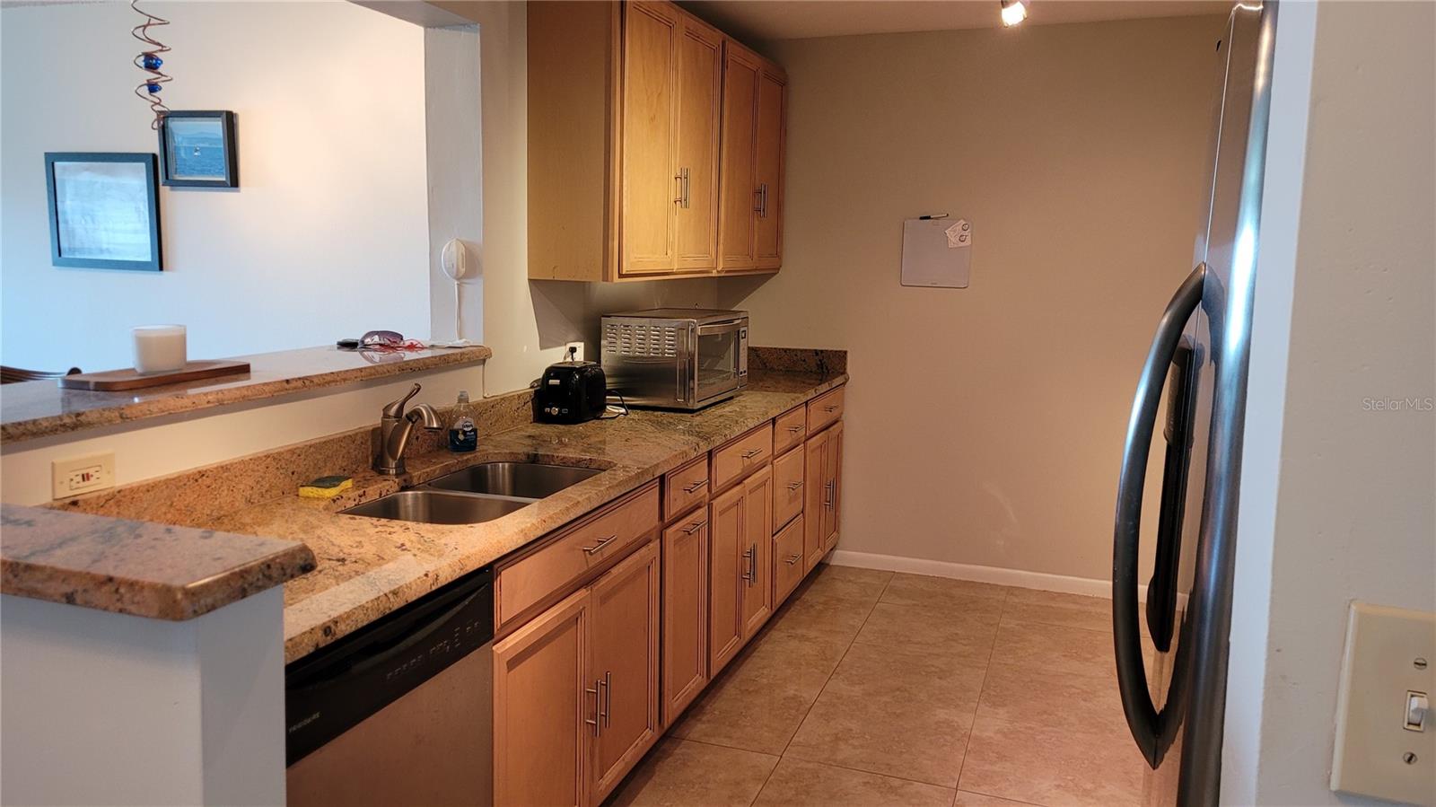 Updated wood cabinets with pass-through to dining area