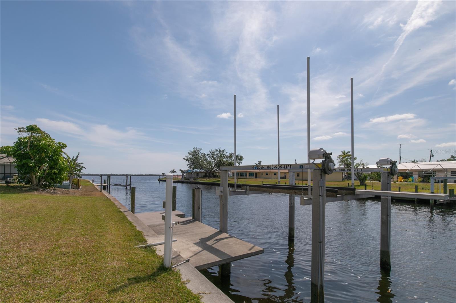View of dock and boat lift with concrete pilings