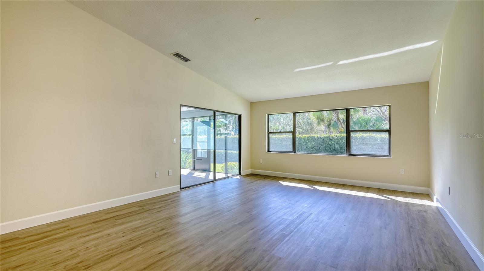 Spacious living room with large windows to enjoy natural lighting and vaulted ceilings