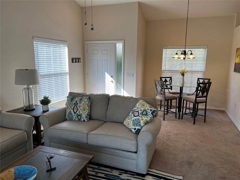 Living room with view into the front door and dining room