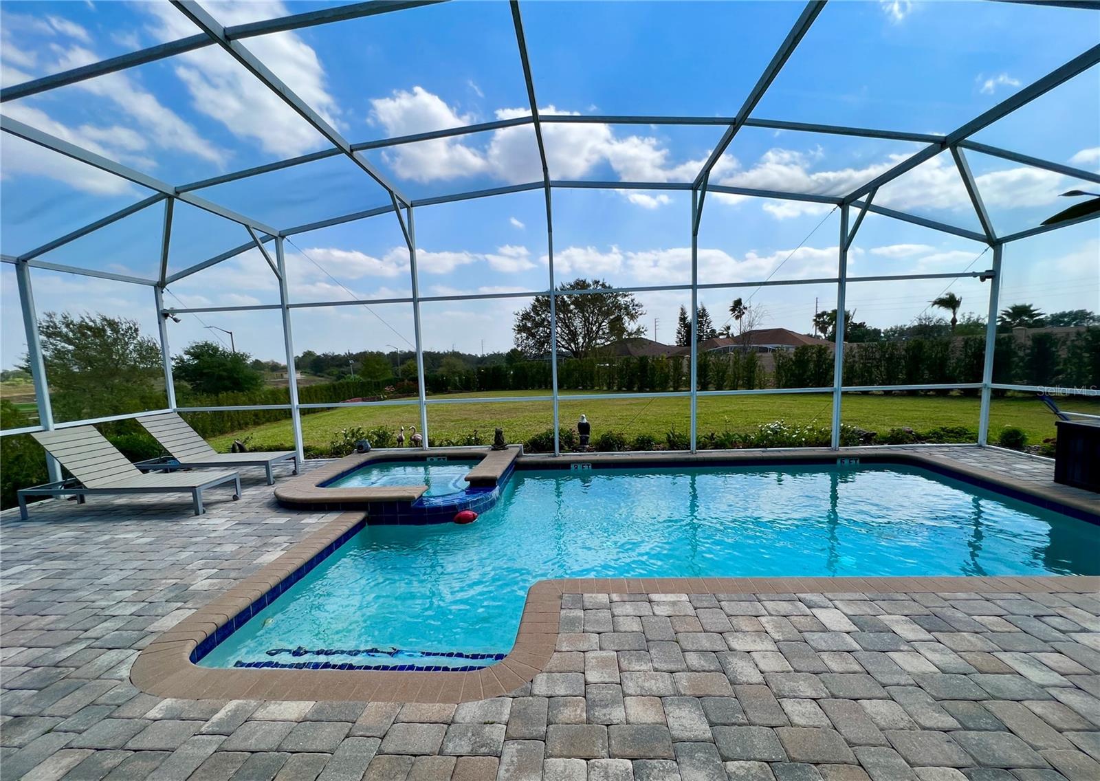 Paved and screened back porch with a pool