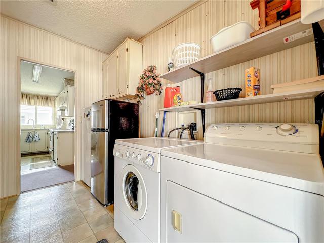 The laundry room offers plenty of space and an additional refrigerator