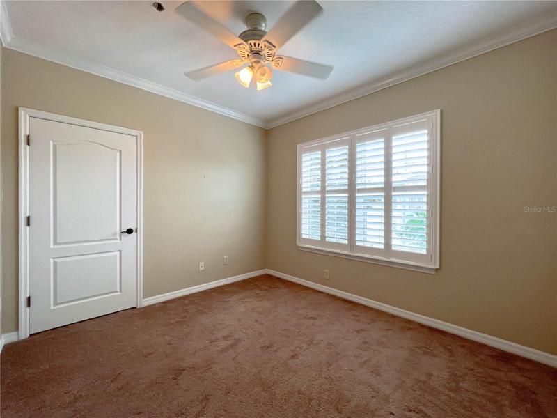 2ND BEDROOM COMPLETE WITH CROWN MOULDING, BAHAMA SHUTTERS, IMPRESSIVE CLOSET DOOR!