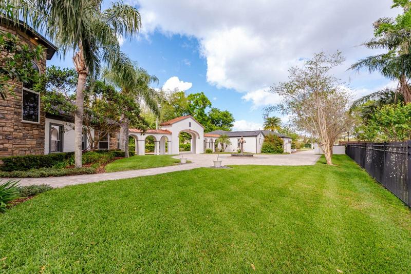 Before you tour the interiors, take some time to explore the grounds that include a circular paver driveway, covered breezeway that connects the homes with an arching entrance to access the garages in the rear!
