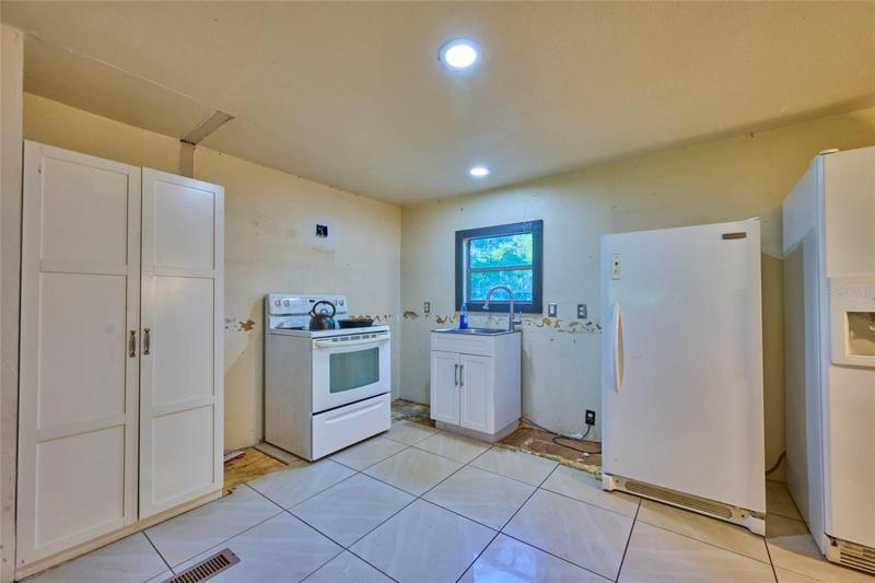 Kitchen is useable as-is, but cabinets have been removed to prep for a remodel