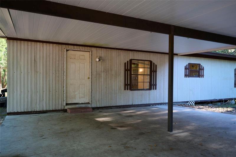 Door from beneath the carport offers access to the indoor utility room