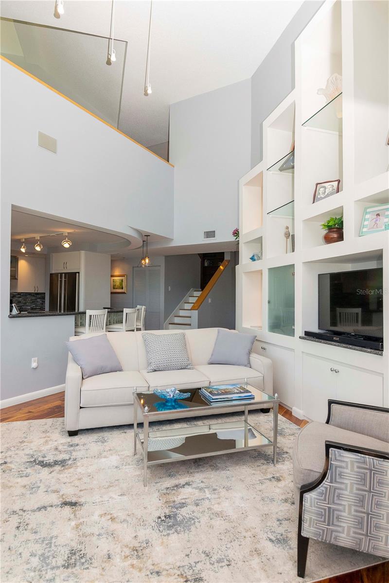 The main living space enjoys abundant natural light from the multiple windows and glass sliding doors.