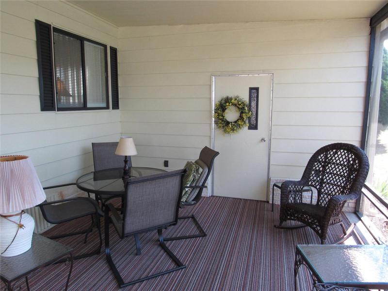 Screen room with attached golfcart/utility room.