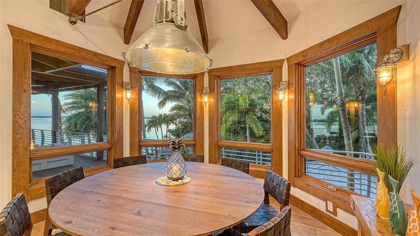 Dining area adjacent to the kitchen and great room, features bay and pool views.