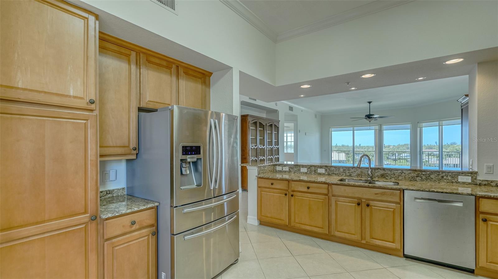 View kitchen pantry and refrigerator toward breakfast bar and living room.