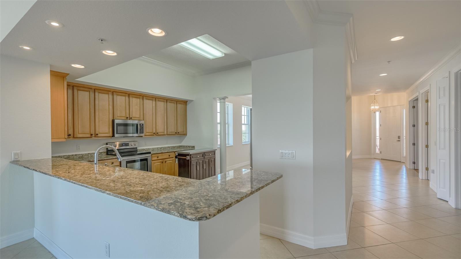 View toward kitchen breakfast bar from Living room and entry hallway